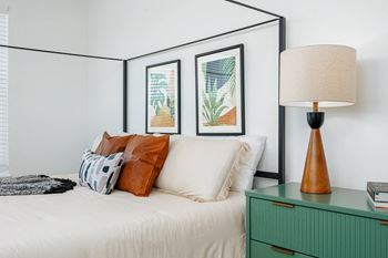 a bedroom with a bed and a lamp and pictures on the wall